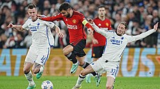 Bruno Fernandes z Manchesteru United (uprosted) proskakuje mezi soupei z...
