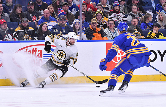 Úto�ník Bostonu Pavel Zacha kontroluje puk, napadá ho obránce Buffala Rasmus...