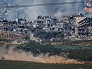 Izraelský tank projídí Gazou, ze které stoupá kou. (11. listopadu 2023)