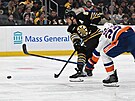 David Pastrák (v tmavém) z Boston Bruins stílí na bránu New York Islanders,...