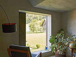 Velkoformátová okna hledící do okolní krajiny vnáí do domu pestré barvy...