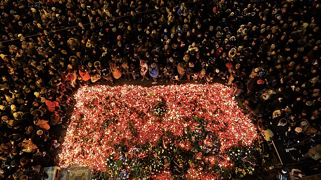 Lidé zapalují svíčky u památníku 17. listopadu na Národní třídě při příležitosti Dne boje za svobodu a demokracii a Mezinárodního dne studentstva. (17. listopadu 2023)