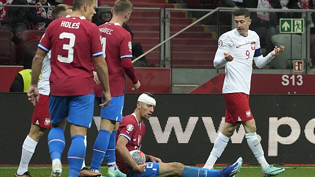 Polsk kapitn Robert Lewandowski rozhazuje rukama (vpravo), esk kapitn Tom Souek po jeho faulu sed na zemi.