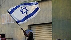 Dívka mává izraelskou vlajkou bhem podprného shromádní ped synagogou v...