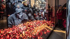 Lidé zapalují svíčky u památníku 17. listopadu na Národní třídě při...
