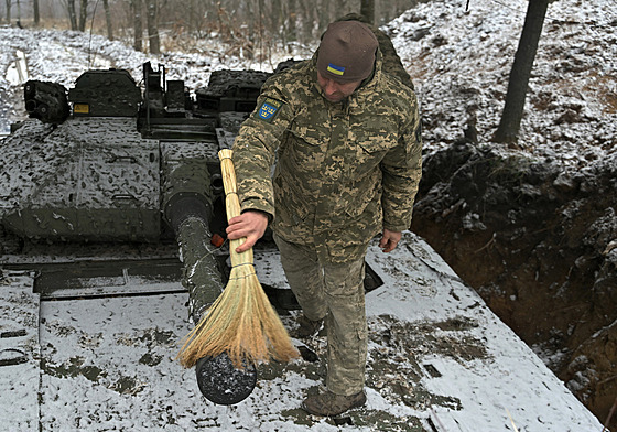 Ukrajinský voják odklízí sníh z obrnného bojového vozidla pchoty CV90 védské...