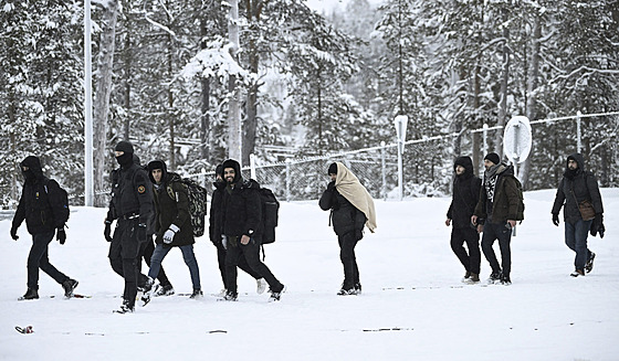 Finská pohraniní strá doprovází migranty picházející na hraniní pechod...