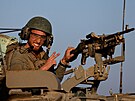 Izraelský voják gestikuluje z vojenského vozidla, kdy projídí kolem...