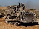 Izraeltí vojáci gestikulují z vojenského vozidla, které projídí kolem...