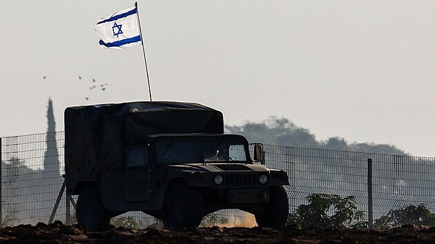 Izraelská vlajka na vojenském vozidle -- konvoj izraelských vojenských tanků a obrněných transportérů (APC) projíždí kolem izraelských hranic poté, co opustil Gazu během dočasného příměří. (24. listopadu 2023)