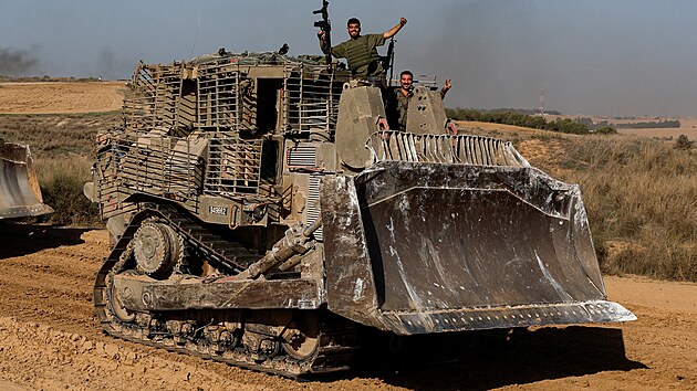 Izraelští vojáci gestikulují z vojenského vozidla, které projíždí kolem izraelských hranic po opuštění Gazy během dočasného příměří. (24. listopadu 2023)
