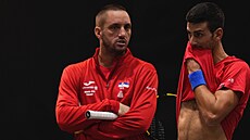Srbský kapitán Viktor Troicki a Novak Djokovič diskutují během tréninku před...