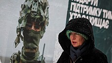 ena prochází kolem reklamního plakátu s ukrajinským vojákem v Kyjev. (27....