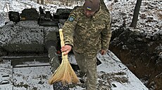 Ukrajinský voják odklízí sníh z obrnného bojového vozidla pchoty CV90 védské...