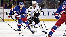 Bostonský útočník David Pastrňák mezi bránícími hráči New York Rangers