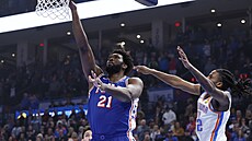 Joel Embiid (vlevo) z Philadelphie zakonuje v zápase proti Oklahom.