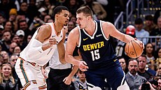 Victor Wembanyama (vlevo) ze San Antonio Spurs brání Nikolu Joki�e z Denver...