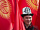 muž v národní čepici stojí mezi státními vlajkami u příležitosti Dne vlajky a...
