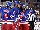 Hokejisté NY Rangers Jacob Trouba, K'Andre Miller a Mika Zibanejad se radují ze...