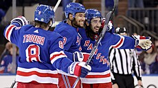 Hokejisté NY Rangers Jacob Trouba, K'Andre Miller a Mika Zibanejad se radují ze...