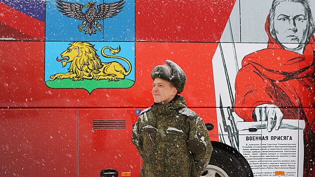 Vojk stoj ped mobiln smluvn nborovou kancele rusk armdy v ruskm Belgorodu. (1. prosince 2023)