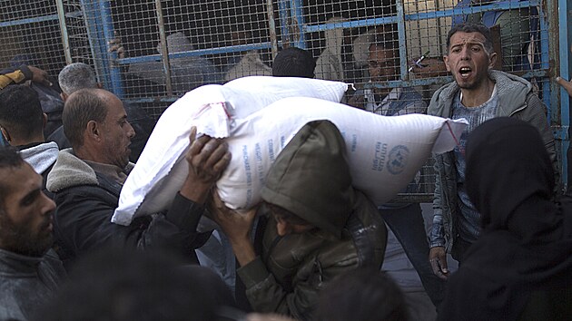 Mu nese pytle s moukou, zatmco se Palestinci shromauj ped distribunm centrem OSN v Chn Jnisu na jihu psma Gazy. (30. listopadu 2023)