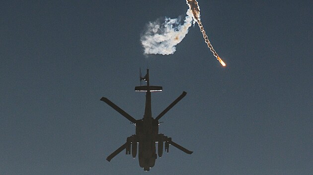 Izraelský vojenský vrtulník vypouští světlici nad hranicí mezi Izraelem a Gazou. (1. prosince 2023)
