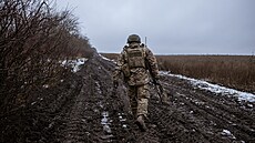 Voják ukrajinské armády kráčí po rozblácené cestě na frontě u města Vuhledar v...