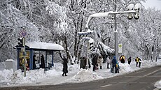 Cestující ekají na autobus na zasnené zastávce v Mnichov. (4. prosince 2023)