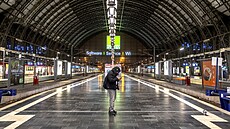Mu kontroluje svj telefon na hlavním vlakovém nádraí v nmeckém Frankfurtu...