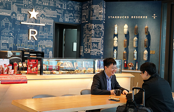 Zákazníci v kavárn amerického etzce Starbucks v Pekingu (27. listopadu 2023)