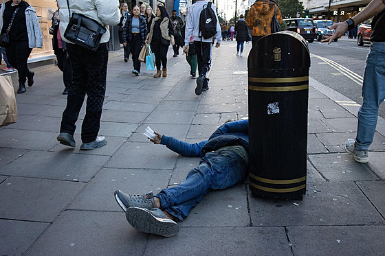 Bezdomovec ebrá o peníze na chodníku na Oxford Street. (25. íjna 2023)