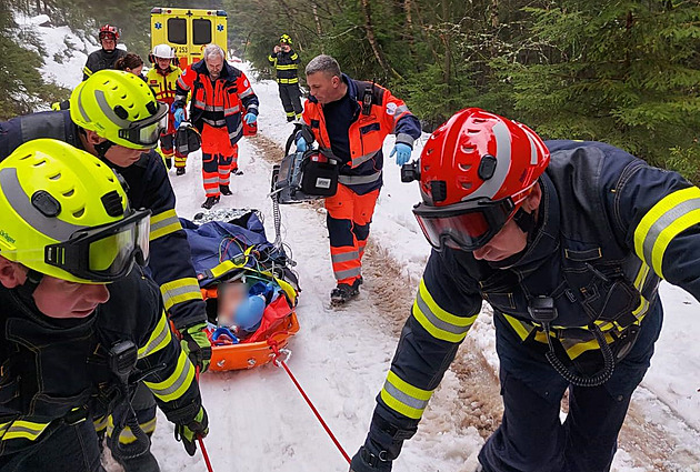 Dřevorubce zranil padající strom, hasiči ho z lesa táhli k vrtulníku po sněhu