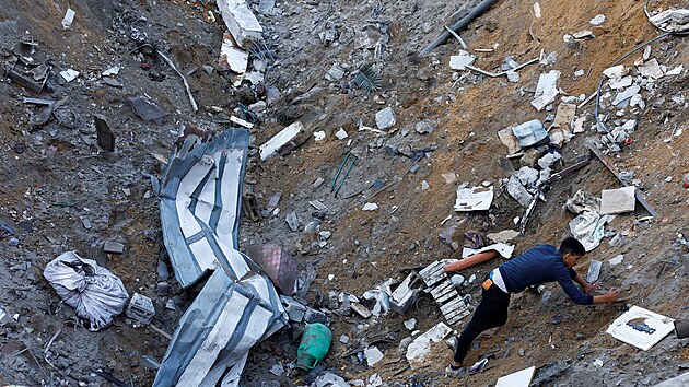 Palestinci hledaj obti na mst izraelskch tok v Rafhu na jihu Psma Gazy. (12. prosince 2023)