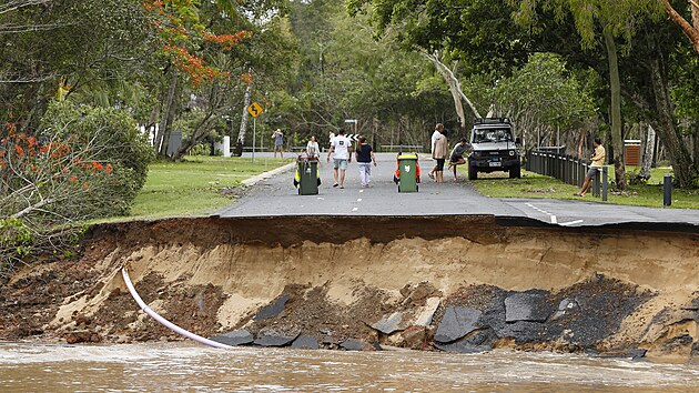 Uvzl obyvatel stoj na silnici, jej velkou st odplavila voda, na pedmst Holloways Beach v australskm Cairns. (18. prosince 2023)