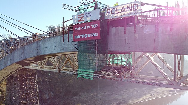 �elezni�n� most p�es Orl�k bude kompletn� hotov� v roce 2025. Za nov�m obloukem je dob�e vid�t i konstrukce star�ho mostu.