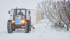 Traktor s pluhem odhrnuje sníh ve Zbýov na Brnnsku. (10. prosince 2023)