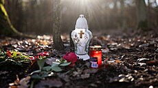 Otec oběti zapaluje svíčky na místě vraždy v lese u Klánovic. (18. prosince...