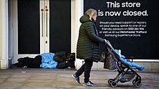 Bezdomovec leí u dveí zaveného obchodu v britském Manchesteru. (22....