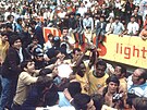 Pelé drí trofej pro svtové ampiony obsypaný davem fanouk a reportér.