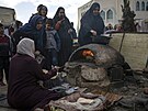 Vysídlení Palestinci peou chleba v provizorním stanovém táboe v oblasti...