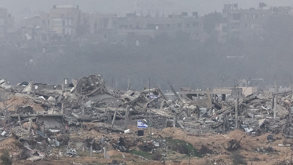 Izraelské vlajky vlají vedle trosek zniených budov v Gaze. (23. prosince 2023)