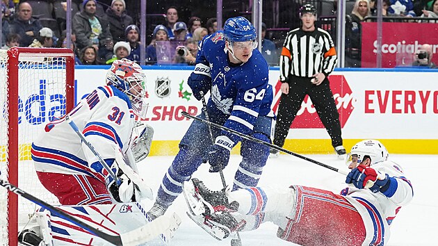 David Kmpf (64) z Toronto Maple Leafs ped brnou New York Rangers, kterou hld Igor esorkin.