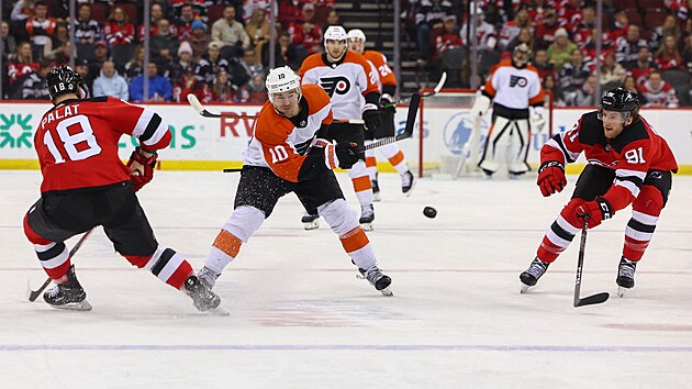 Bobby Brink (10) z Philadelphia Flyers stl na brnu New Jersey Devils kolem Ondeje Palta (18).