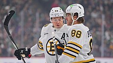 Charlie McAvoy (73) gratuluje Davidu Pastrákovi ke dvacátému gólu sezony,...