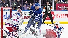 David Kämpf (64) z Toronto Maple Leafs ped bránou New York Rangers, kterou...