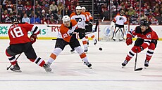 Bobby Brink (10) z Philadelphia Flyers stílí na bránu New Jersey Devils kolem...