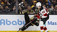 Obránce New Jersey Luke Hughes odstavil Davida Pastr�áka od puku.