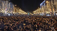 Tisíce lidí oslavují konec roku v centru Paíe, v hlavním mst dohlíí na...