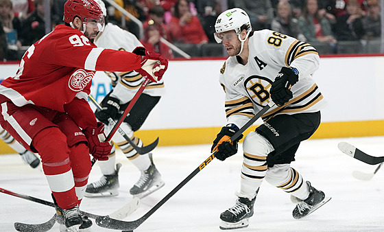 David Pastrňák (vpravo) z Bostonu bráněný Jakem Walmanem z Detroitu.